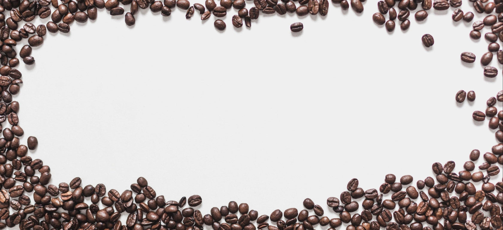 Roasted coffee beans arranged in a circular pattern on a white background